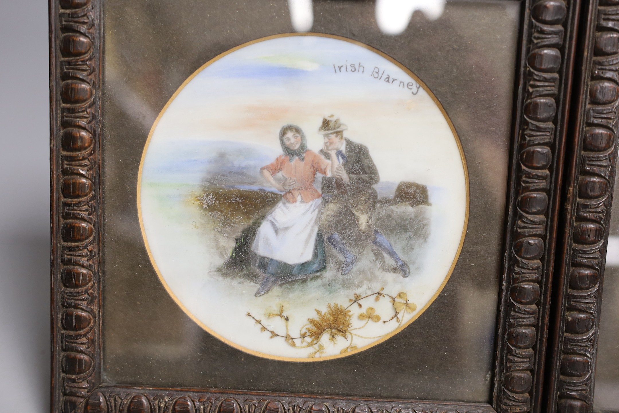 A pair of framed overpainted prints on glass, 13 cms diameter.